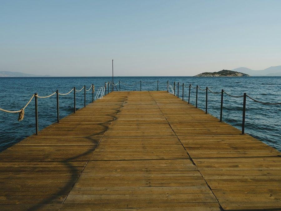 A wooden pier over calm water at sunset