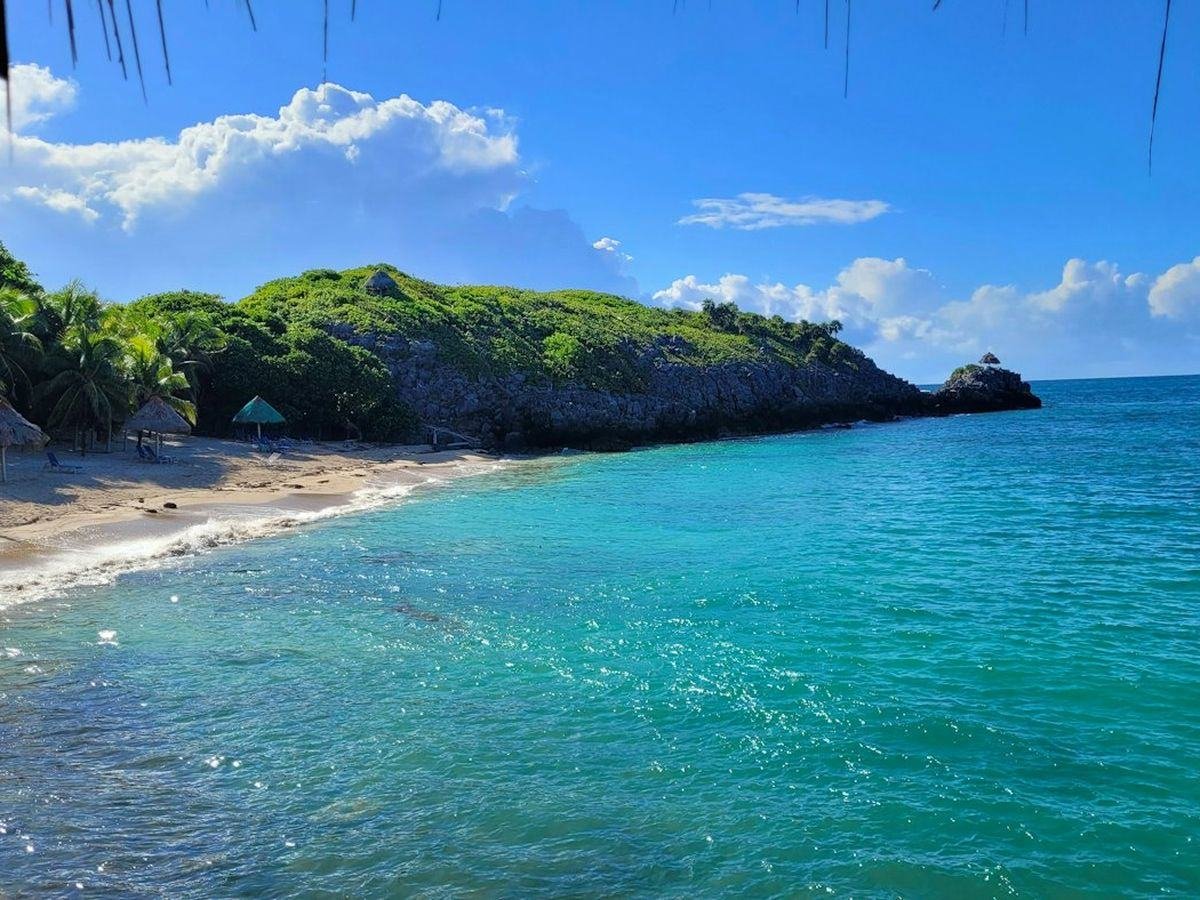 Turquoise water off a green headland in Roatán