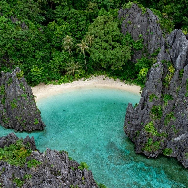 A sandy cove between limestone cliffs