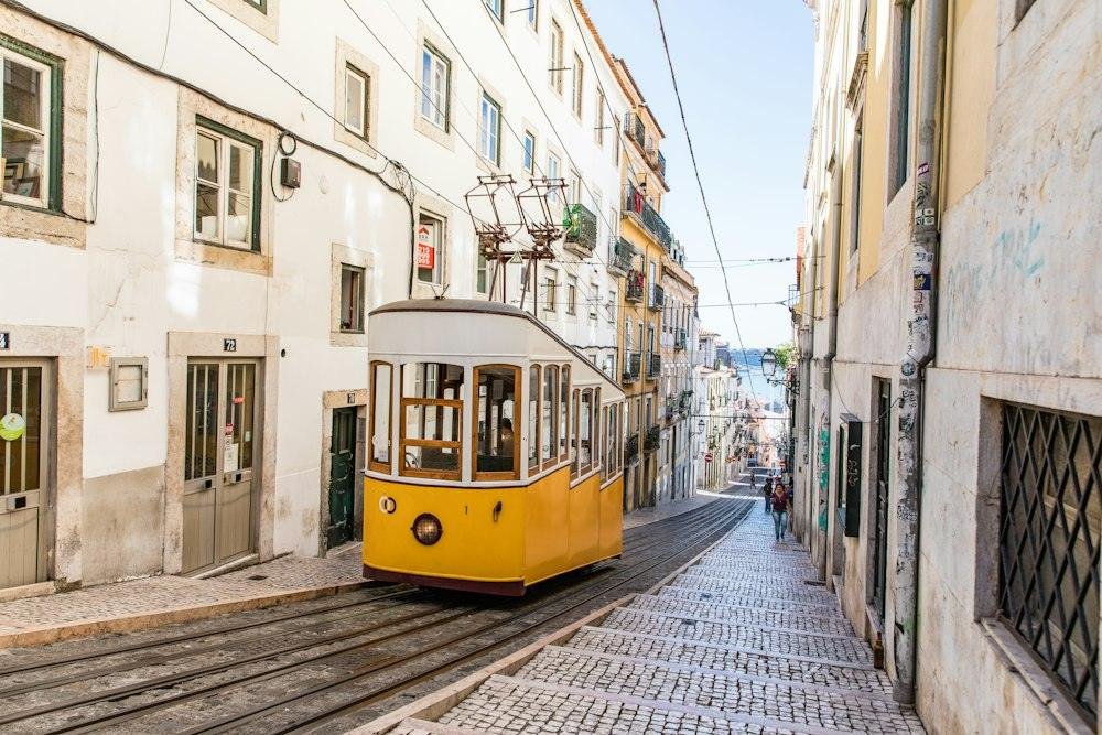 Yellow tram on a steep cobbled street in Lisbon
