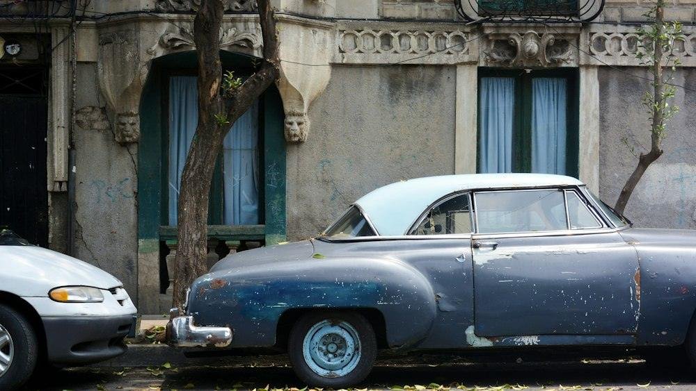 Vintage blue car parked on a leafy street in Mexico City
