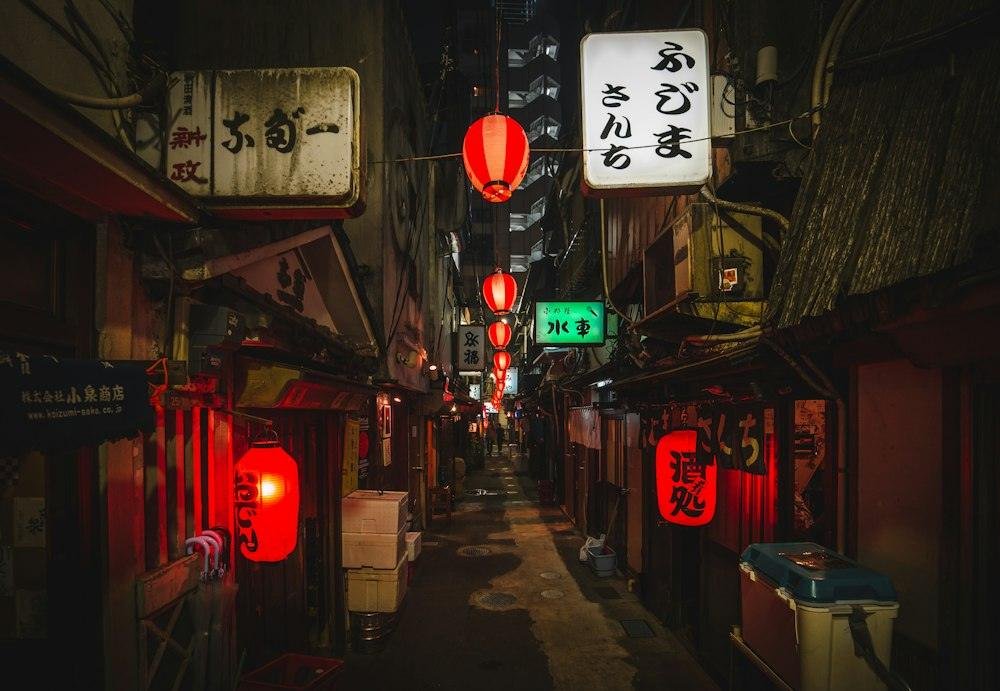 Narrow Tokyo alley at night lit by red lanterns