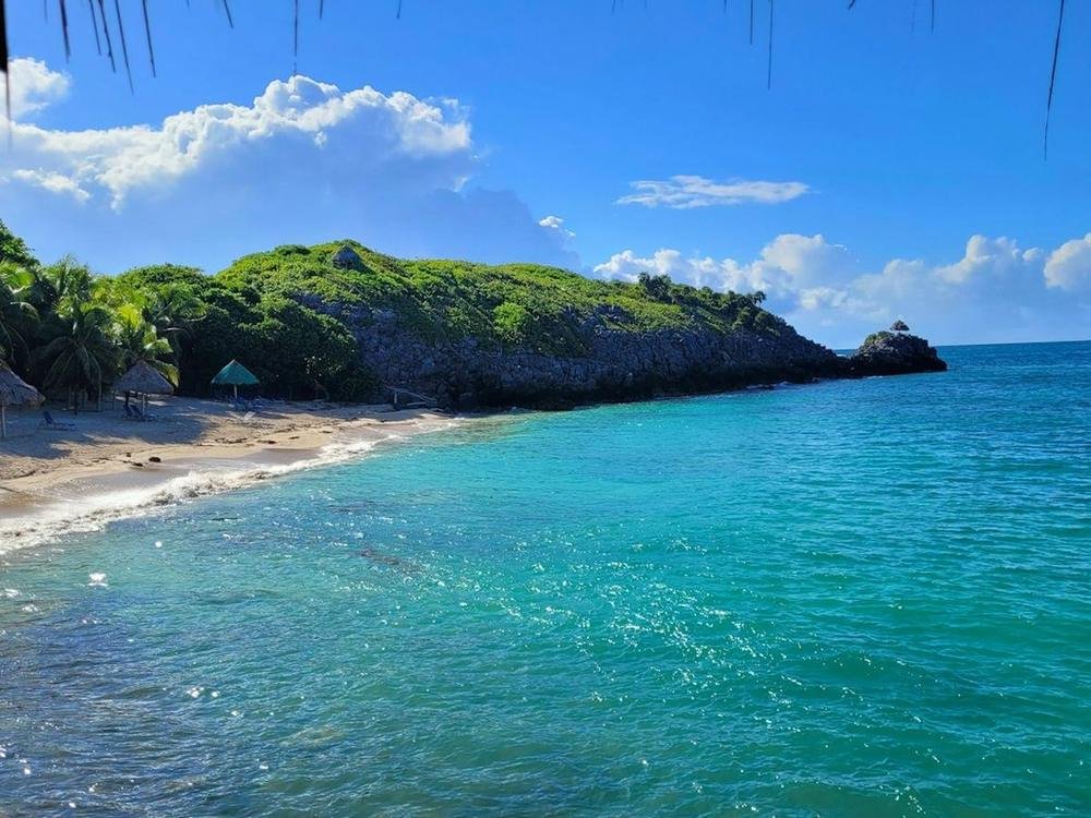 Turquoise water off a green headland in Roatán