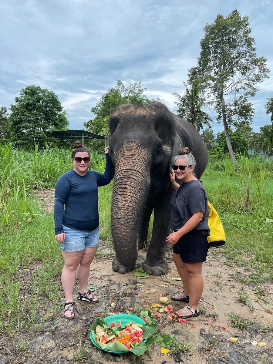 Mariya and Sam standing with an elephant in Thailand