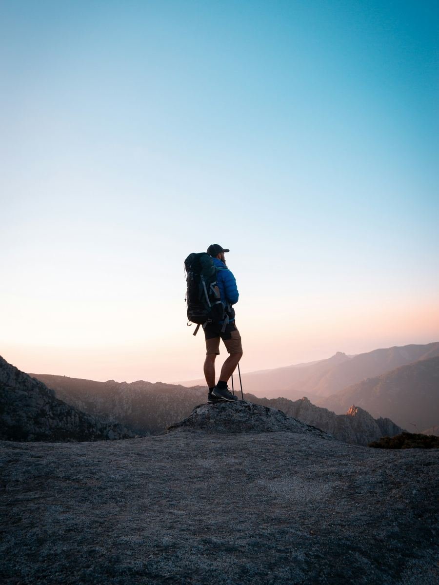 Hiker on a rocky ridge at sunrise