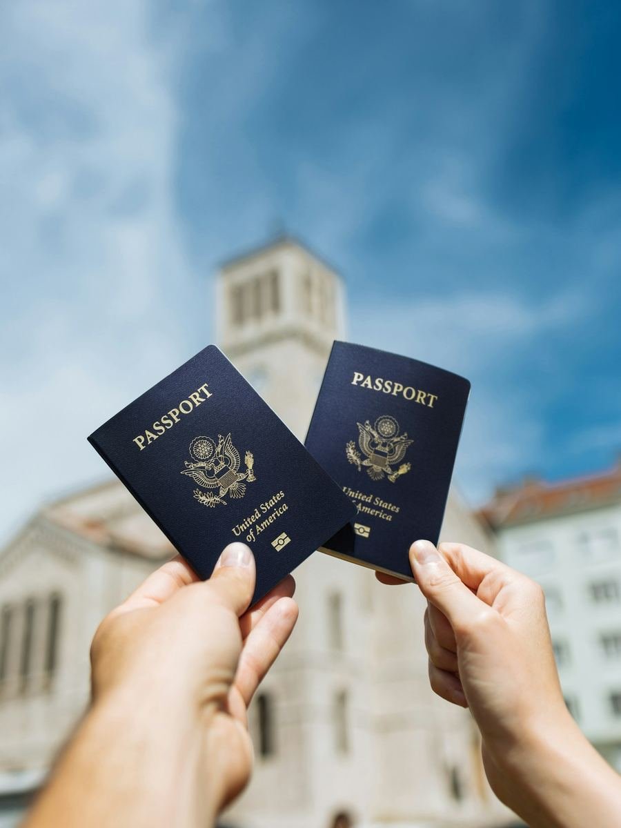 Two passports held up in front of an old building